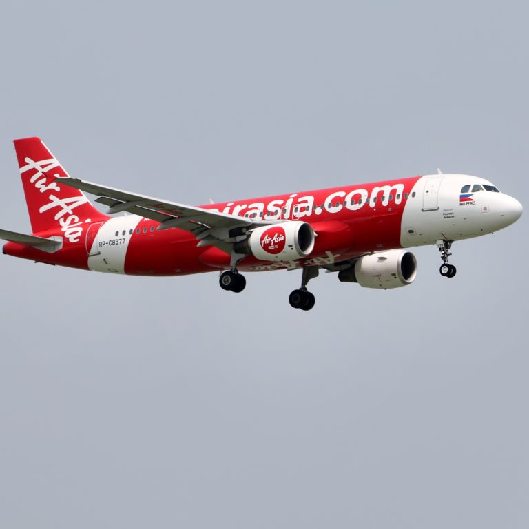 An Air Asia airplane in flight with landing gear extended