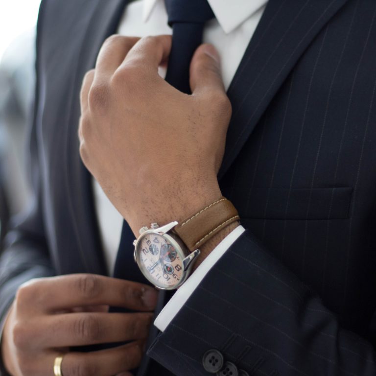 A businessman in a suit fixing his tie